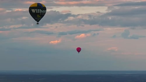 Hot Air Balloons Flying Over the Forest and Lakes at Dusk