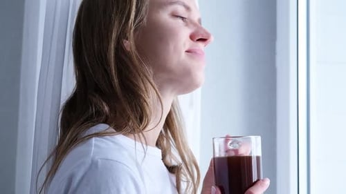 Woman Enjoying Coffee by a Bright Window