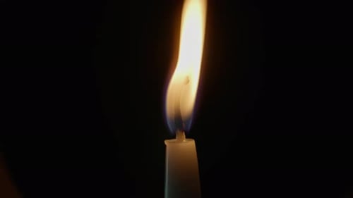 Wind Blowing Candle Flame on Isolated Black Background One Wax Taper Standing