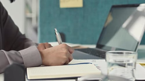 Female Office Worker Writing on Sticker Note