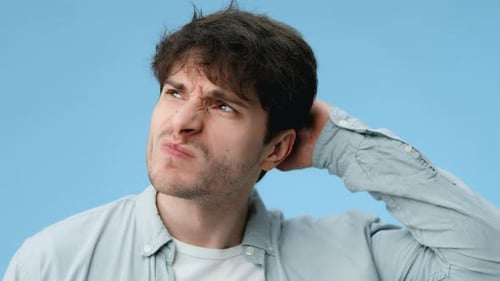 Der Mensch denkt nach, während er seine Lippen vor blauem Hintergrund in einem in Auflösung aufgenommenen Video berührt
