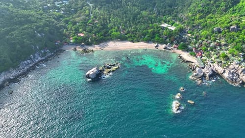 Sandy beach shore with beautiful resort surrounded by clear sea water.