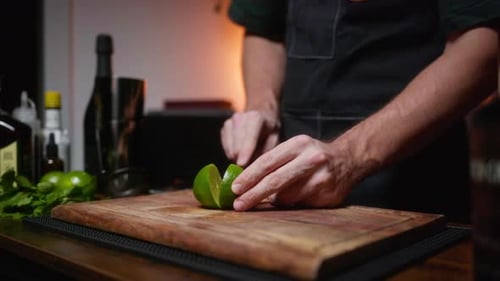 Close-up of lime being sliced on wooden board. Perfect for cocktail recipes or cooking shows.