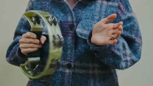 Hands Rhythmically Shake Intimate Closeup Capturing Hands Shaking Tambourine in Lively Folk Musical