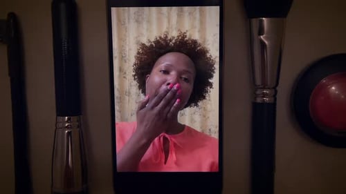 Influenciadora de maquillaje femenina graba un vídeo de un producto de belleza en un teléfono inteligente