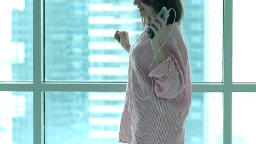 Cheerful Woman Dancing to Music by Window