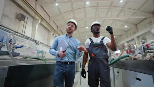 African American Worker and Supervisor Walking While a Meeting in a Factory