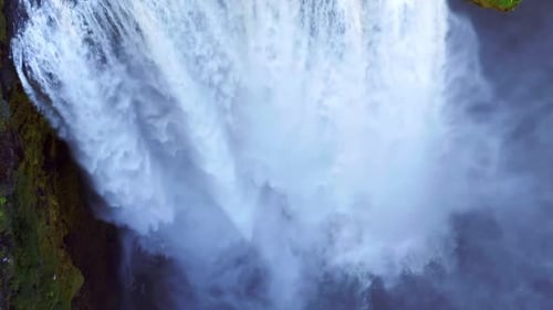 Spectacular Waterfall Of Skogafoss With Foamy Stream Flowing From Steep Mountains In Skógar, Icelan