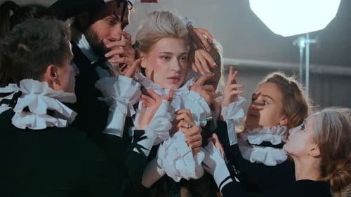 Model Surrounded by Stylists Adjusting Ruffled Collar