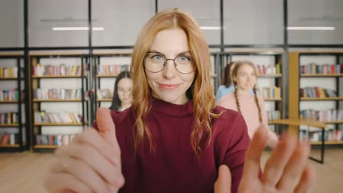 POV A Happy Redhaired Student Blogger Sets Up Her Phone on a Tripod in the University Library to