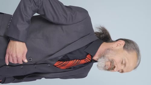Mature Man in Suit Posing on Plain Background