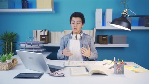 Teen Studying and Talking to Computer at Desk
