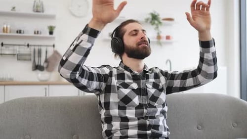 Man Listening to Music on Headphones, Relaxing on Couch