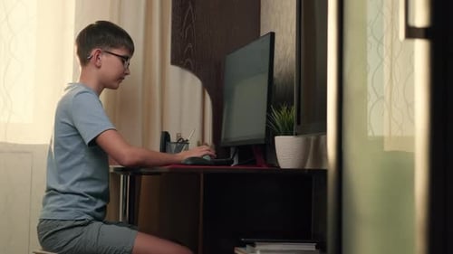 Boy Writes Program Code at Home Using Computer