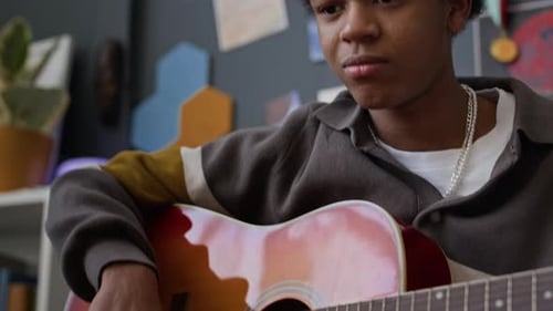 Teen Plays Acoustic Guitar at Home