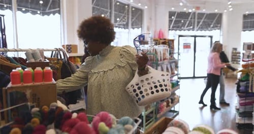 Female Shopper With Basket Browsing In Craft Store Slow Motion