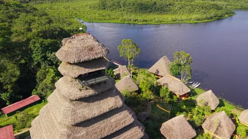 Verdant Rainforest Framing Wooden Ecolodge with Thatched Bungalows Central Observation Tower