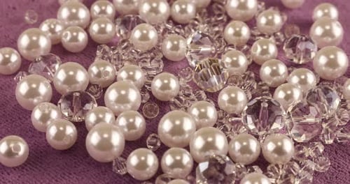 White pearls, clear jewelry crystals and rock crystal on pink velvet.