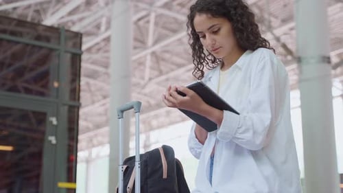 Young Woman Traveler with Tablet Computer at the Station