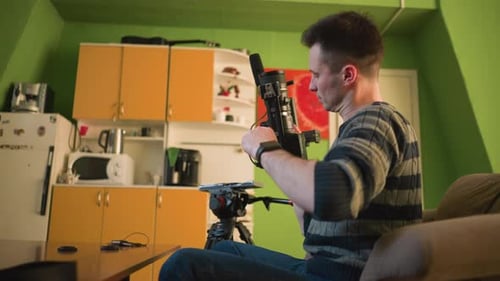 Man Assembling Video Camera Gear Indoors on Table