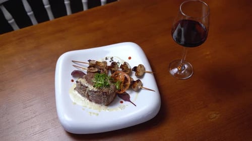 Veal steak and red wine on the table in the restaurant