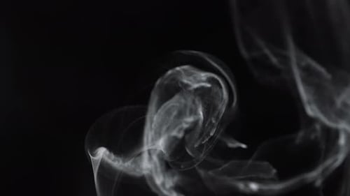 Wispy smoke drifting and swirling in the dark