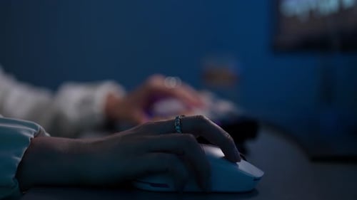 Hand Clicking Computer Mouse in Dark Room at Night