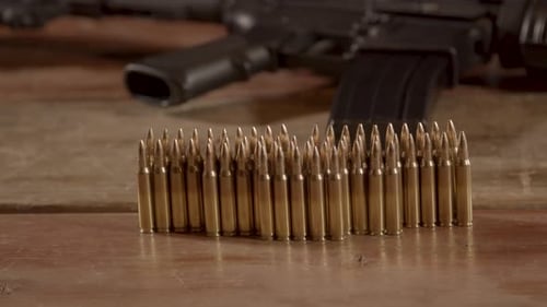 Bullets and a Rifle on a Wooden Table