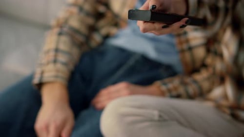 Marido y esposa desconocida en conflicto por un programa de televisión en el sofá del fin de semana