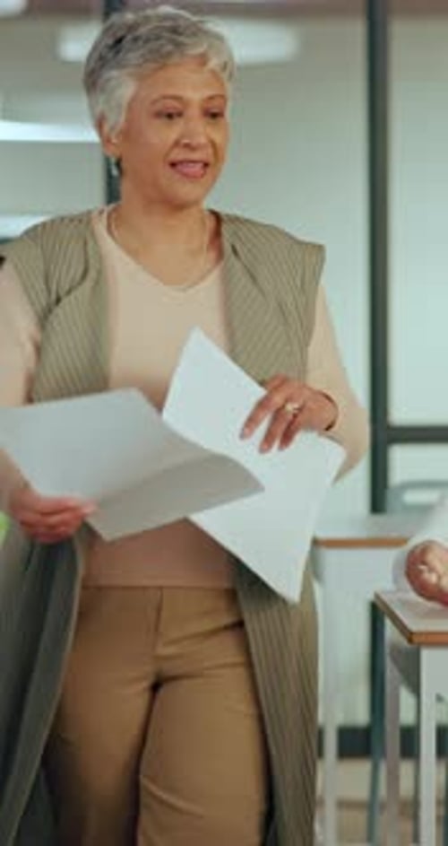 Woman walks to a desk in a school classroom