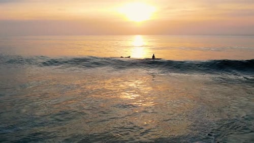 Aerial — Surfer warten auf eine gute Welle bei atemberaubendem Sonnenuntergang