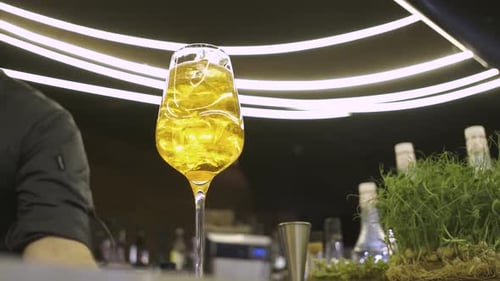 alcoholic cocktail with amber colored ice in a bar