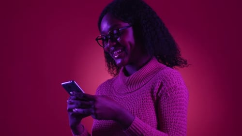 Woman with Smartphone in Pink and Purple Lighting