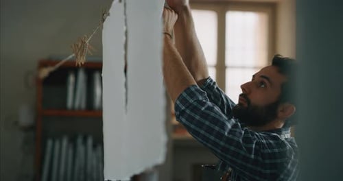 Slow motion of an artisan paper making master is putting to dry high quality handmade paper sheets
