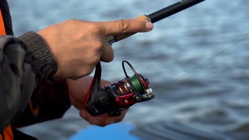 Person Fishing With Reel by the Water