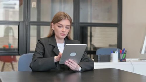 Young Woman Uses Tablet in Modern Office
