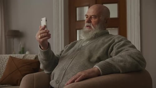 Senior Man Using Smartphone Indoors at Home