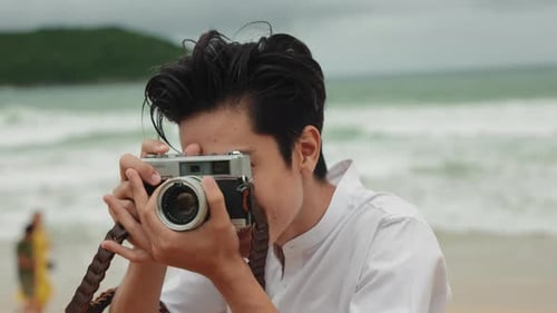 Happy Young Adult Taking Pictures on Beach