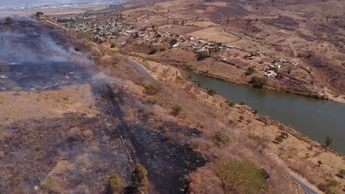 Helicopter firefighting forest fire blaze on La Huasteca Mexico dry grass hillside