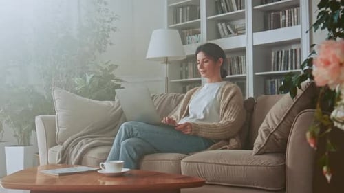 Woman Using Laptop Computer While Relaxing at Home