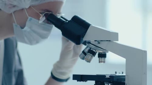 Scientist Working with Microscope in Medical Lab