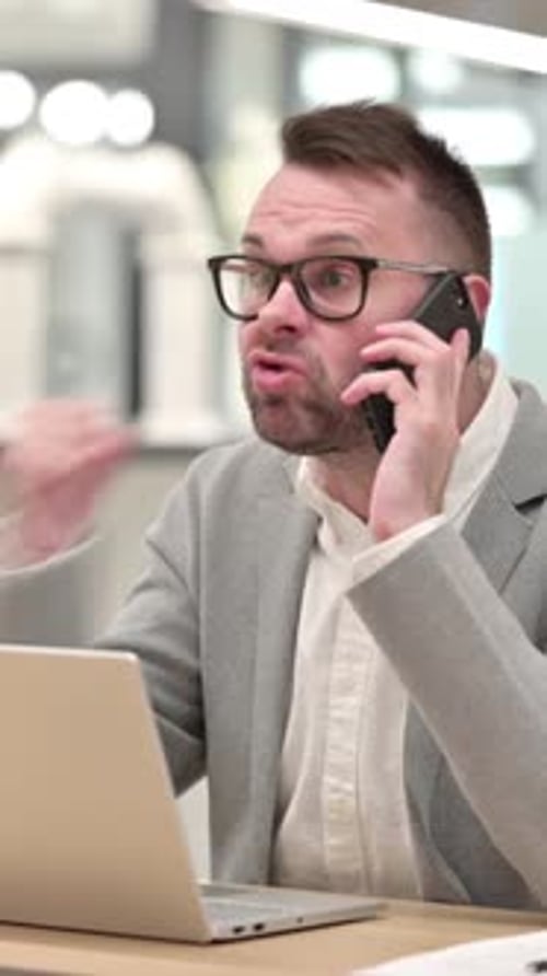 Angry Man Arguing on Cell Phone at Office