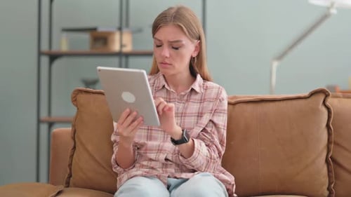 Woman Using Tablet Looks Upset on Couch