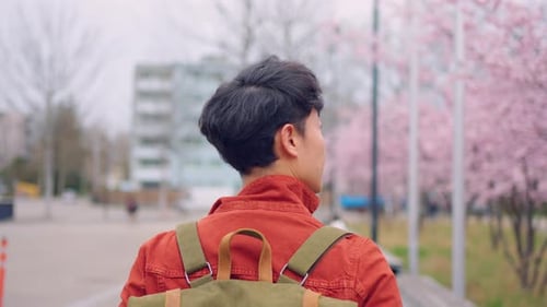 Asian young man backpacker traveler travel and looking around in city.