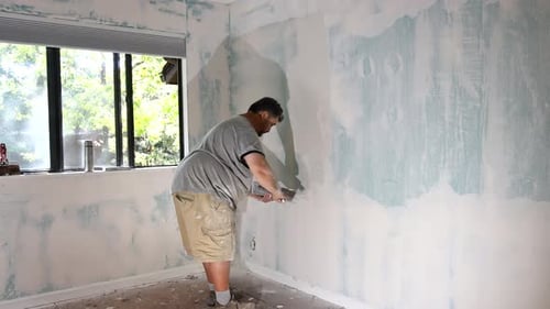 Adult Applies White Filler to Interior Wall