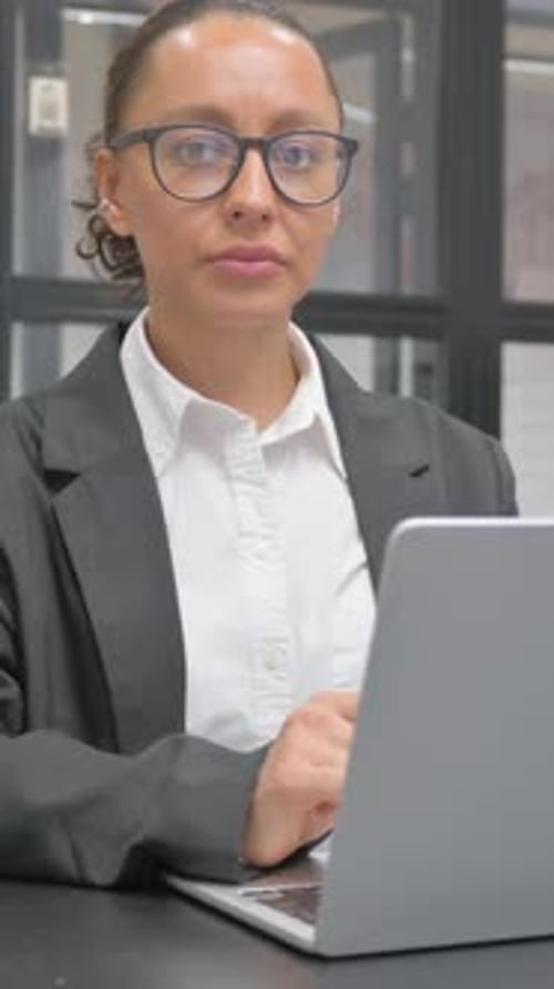 Woman Works on Laptop in Modern Office Setting