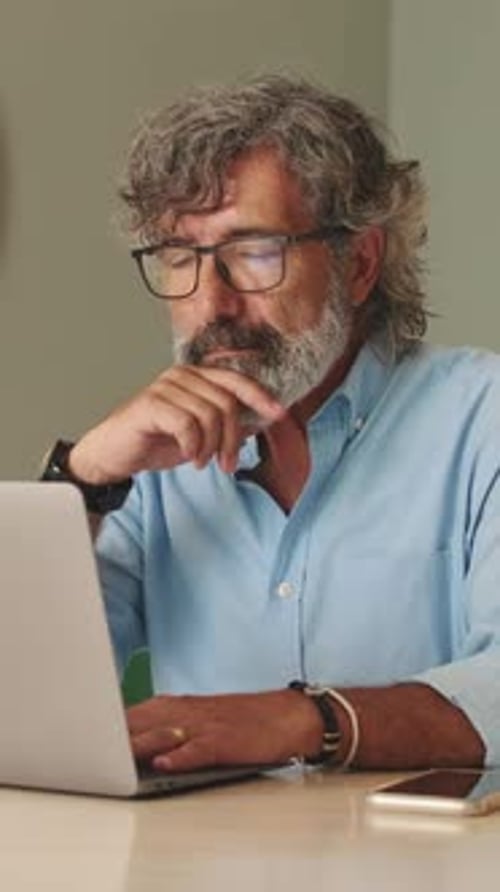 Adult Working on Laptop at Table Indoors