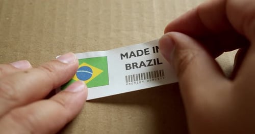 Affixing 'Made in Brazil' Sticker on Brown Cardboard