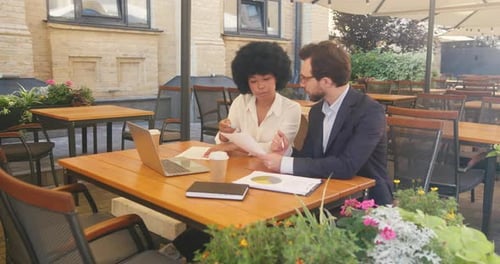 Businesspartners Sitting in Cafe Discuss Plans About Project