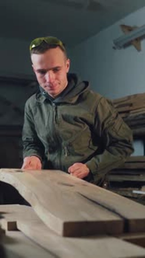 Craftsman Inspecting Freshly Cut Wooden Board